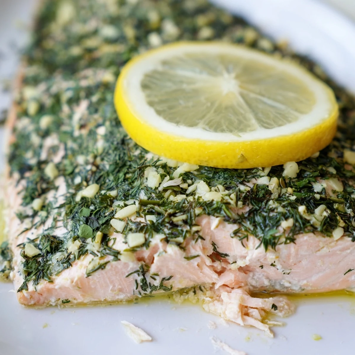 Golden-brown Baked Salmon with Lemon and Herbs, flaky and glistening with fresh dill on a rustic plate.