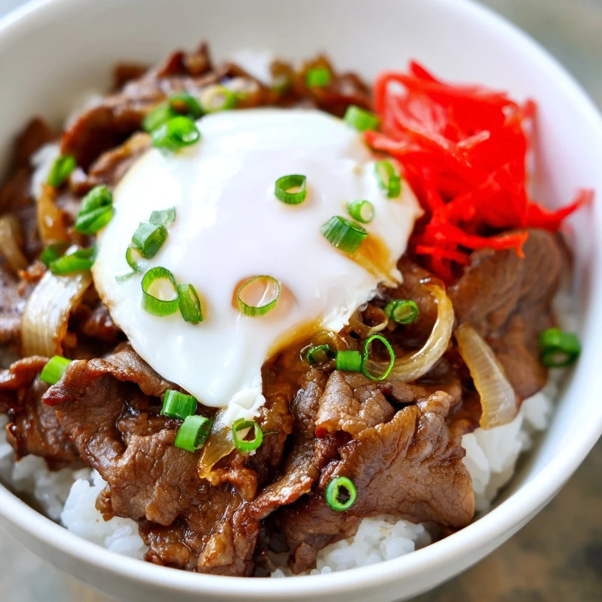 Freshly cooked beef simmers in a sweet soy glaze on top of fluffy white rice in this Beef Bowl with Rice.