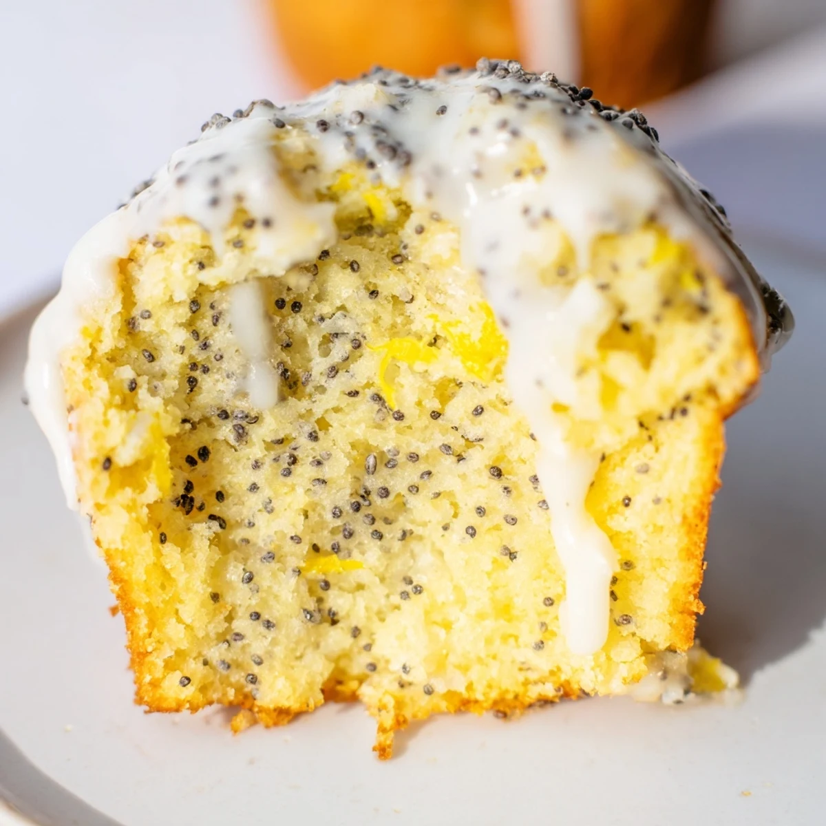Freshly baked Lemon Poppy Seed Muffins with Yogurt sitting on a cooling rack, featuring golden-brown tops and visible poppy seeds.