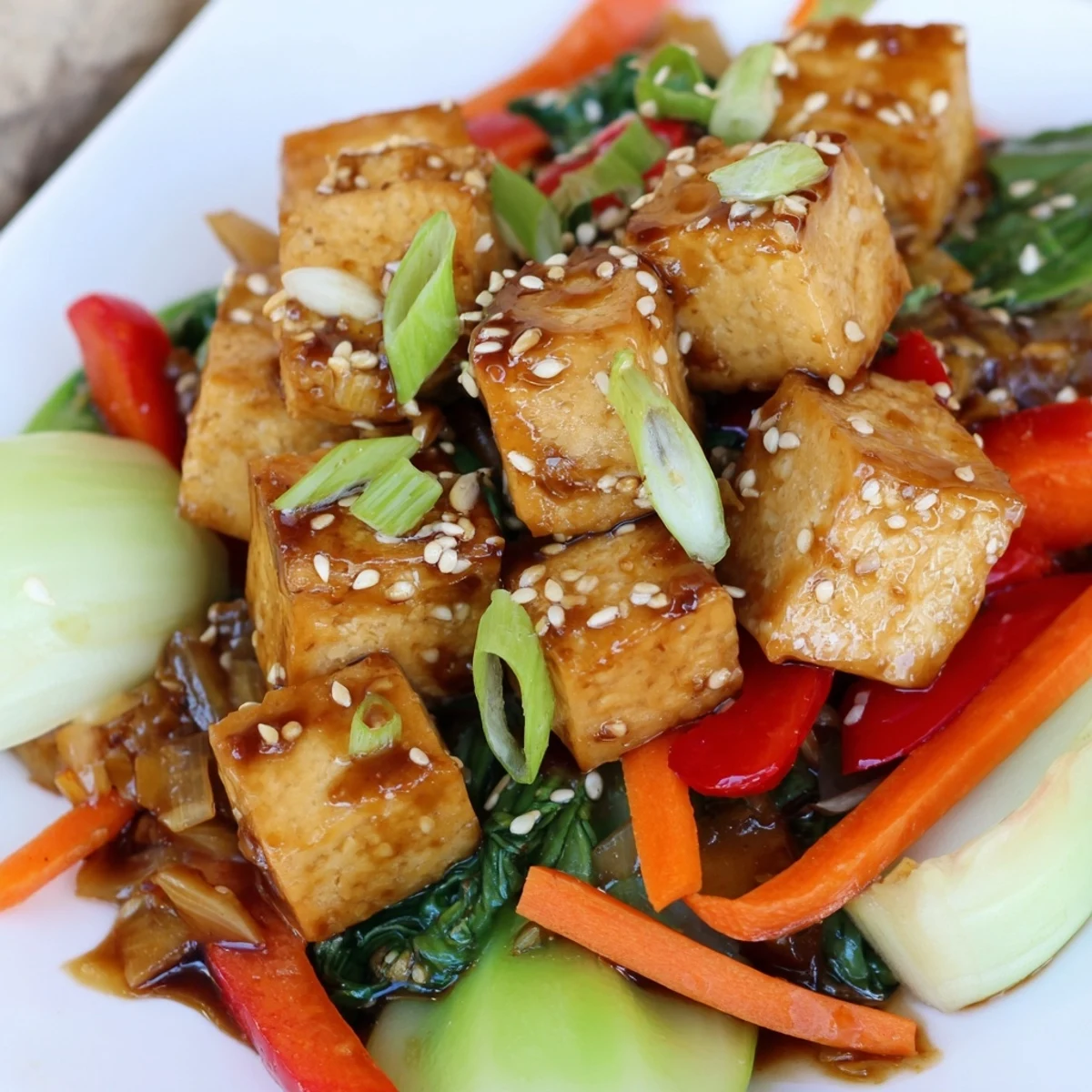 Freshly cooked Crispy Tofu Stir Fry with Bok Choy served steaming hot over a white bowl of jasmine rice.