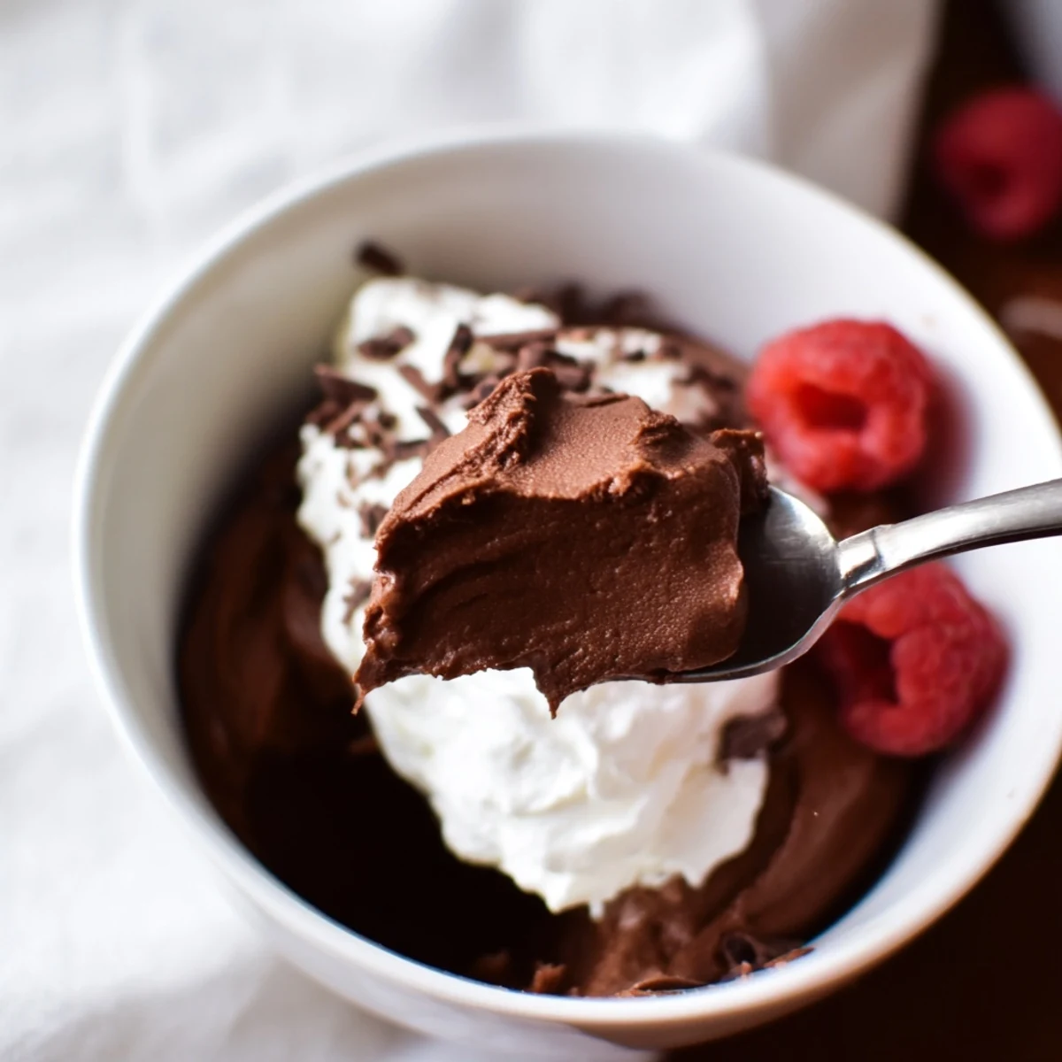 The velvety Chocolate Lunch Dessert layered in a jar with grated chocolate and a strawberry garnish.