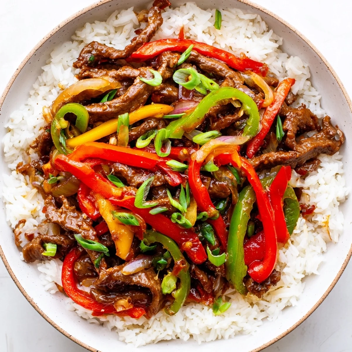 Spicy Beef and Pepper Stir Fry with Rice served steaming hot next to a glass of crisp white wine for dinner.