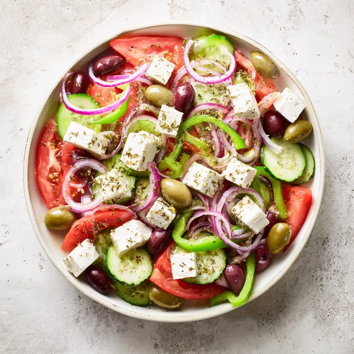Juicy tomatoes and crisp cucumbers combine with briny Kalamata olives and creamy feta in this vibrant Greek salad.  