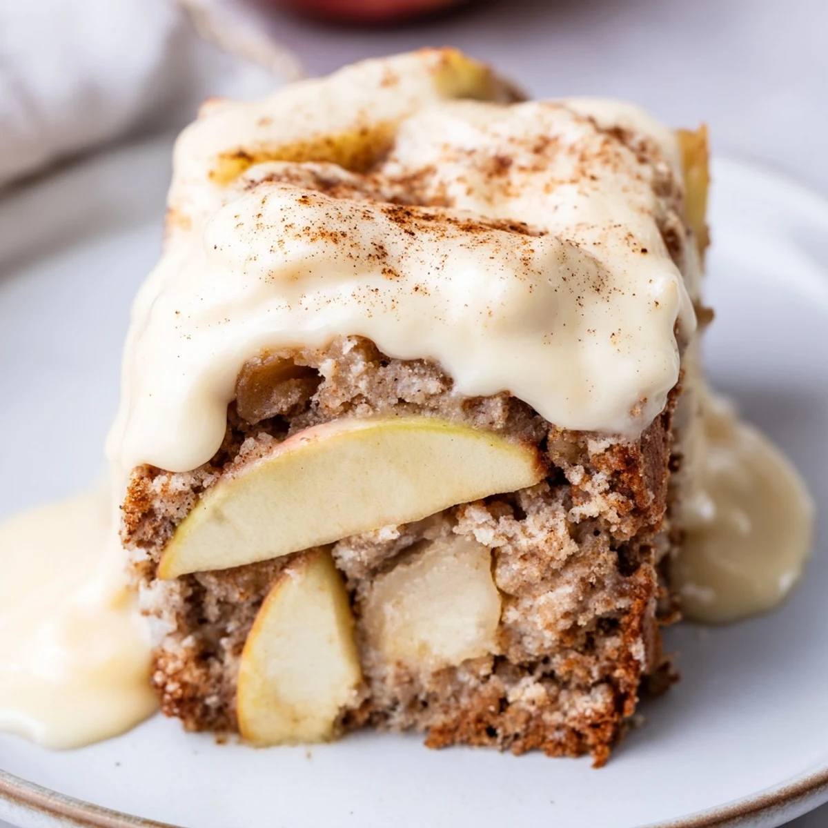 Warm slices of Irish Apple Cake with Custard Sauce, drizzled with creamy vanilla custard and dusted with cinnamon.