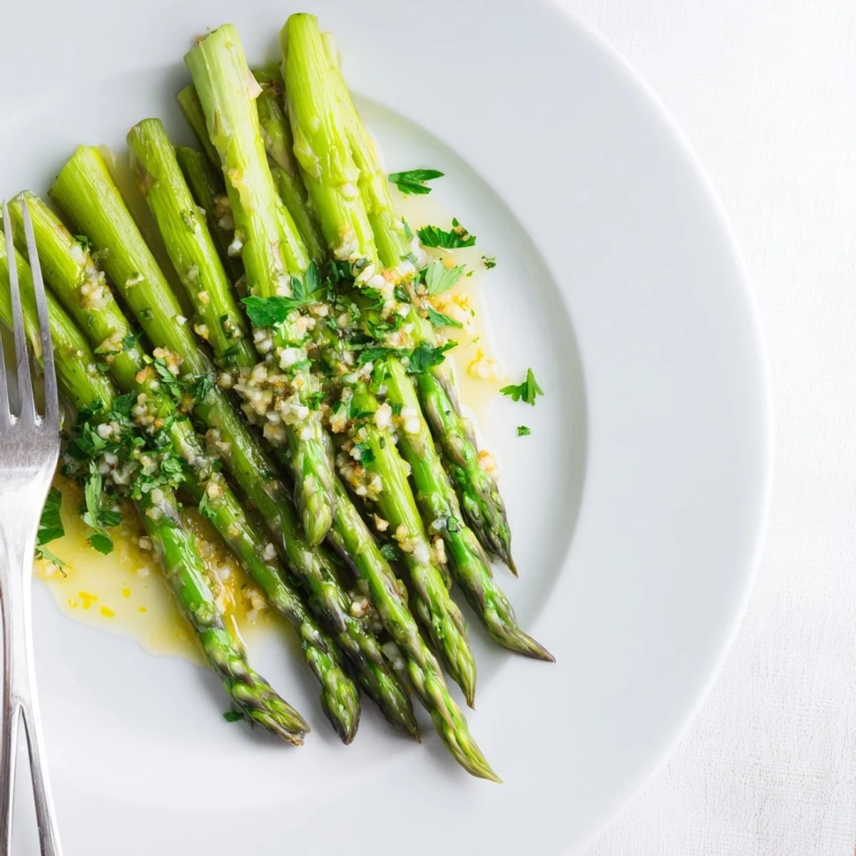 A close-up of Lemon Garlic Asparagus with Butter, steaming beside grilled chicken for a complete dinner plate.