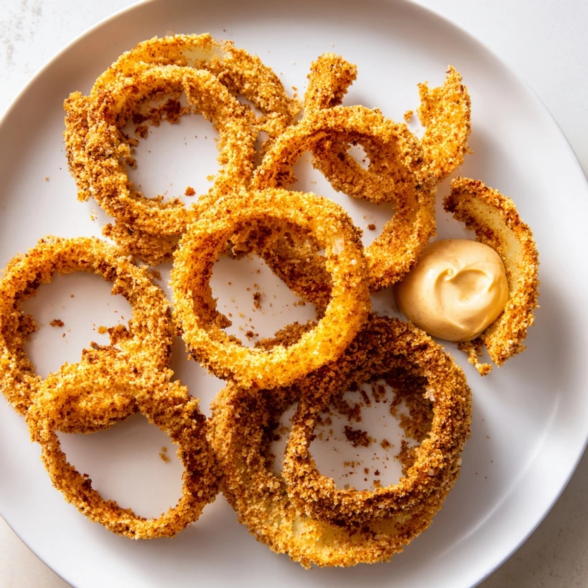 Golden, crispy air fryer onion rings with chipotle mayo, perfectly golden and crunchy after 12 minutes.