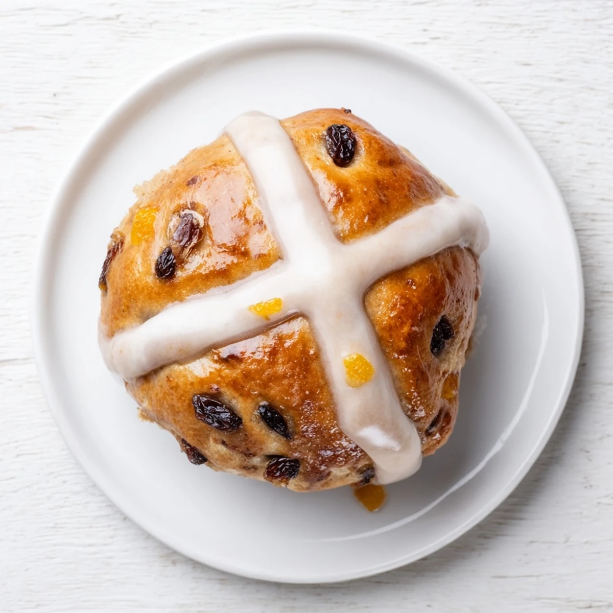 Warm Hot Cross Buns are ready to serve on a white plate, showcasing the soft, spiced interior texture.