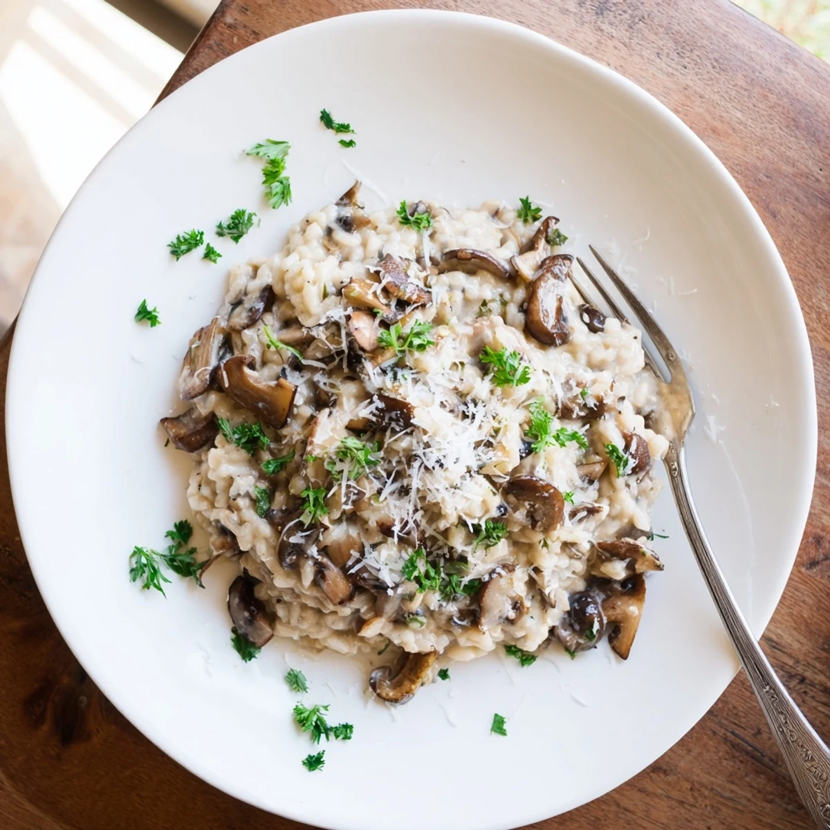 Creamy Mushroom Risotto served in a warm bowl with golden sautéed mushrooms and a glass of white wine.