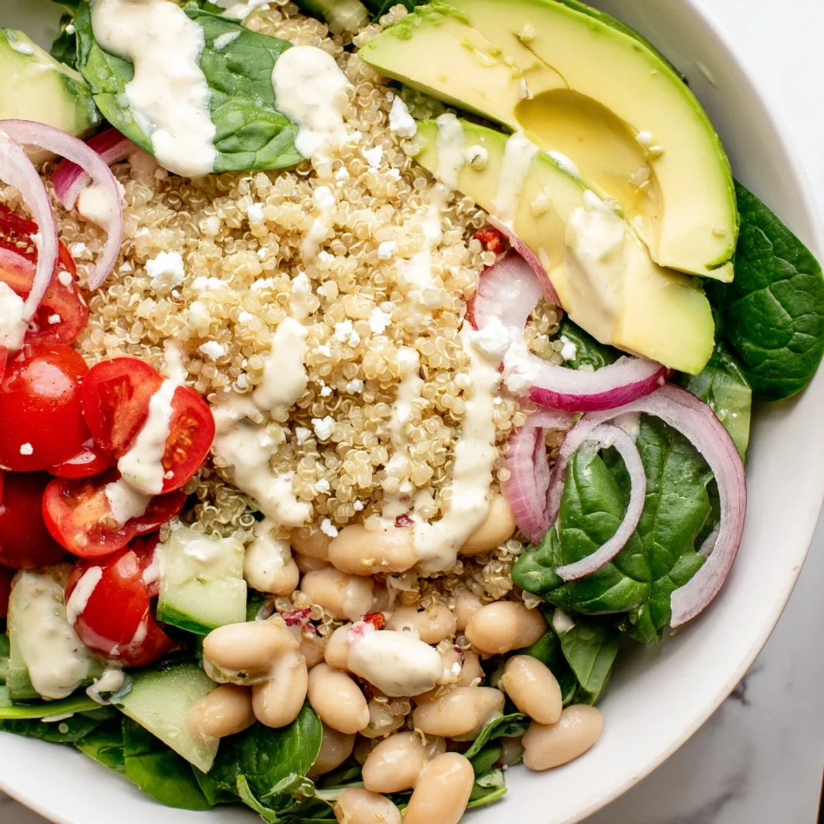 Healthy Spinach & White Bean Ultimate Protein Power Bowl garnished with feta and tomatoes, ready to eat.