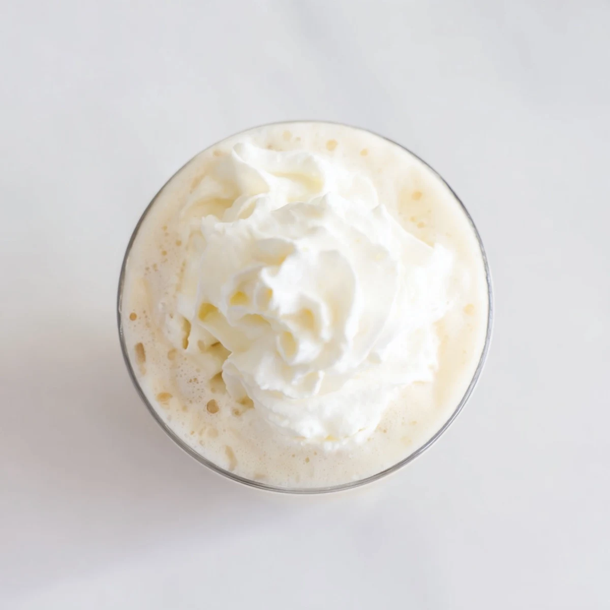 Homemade Starbucks Vanilla Bean Frappuccino in a blender with ice cubes for a creamy texture.