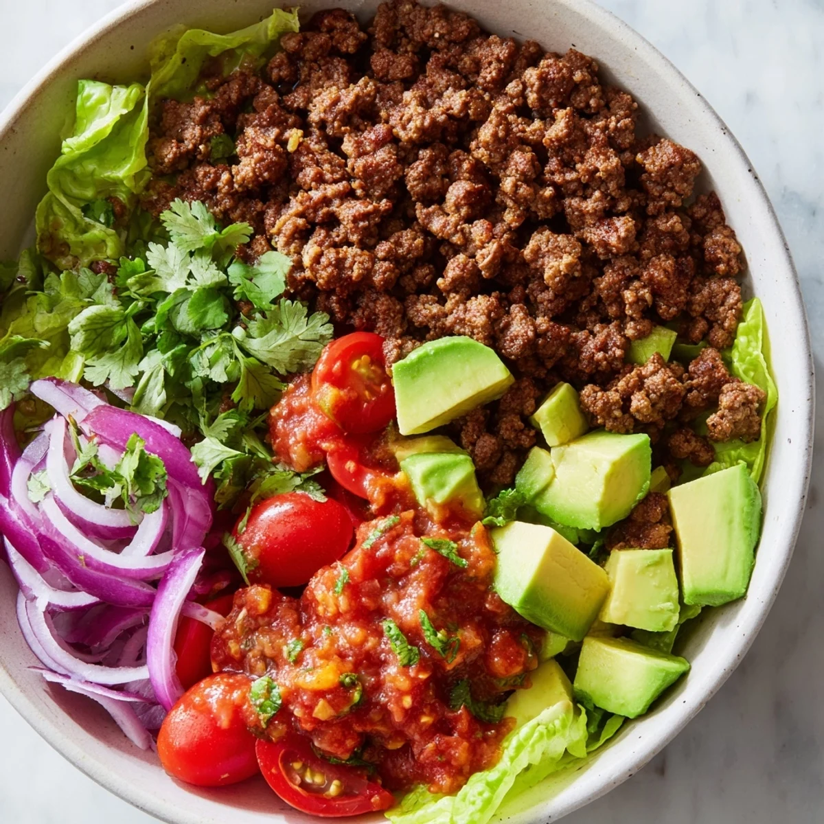 Low Carb Burrito Bowl served with a lime wedge, sour cream dollop, and fresh cilantro, perfect for a healthy Mexican-inspired dinner.