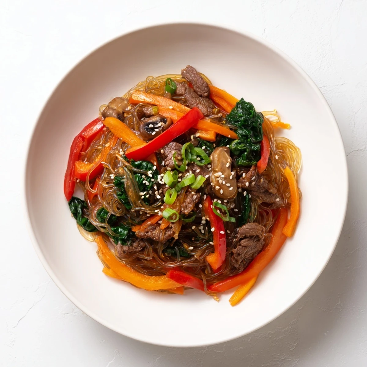 Close-up of Korean Beef Noodles showing juicy beef, crisp veggies, and noodles coated in a glossy, mildly spicy Korean-inspired sauce.