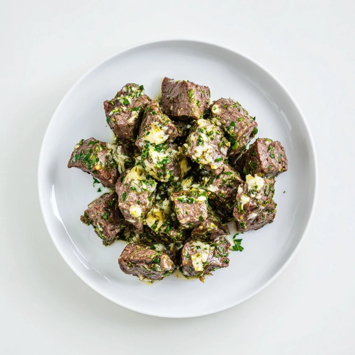 Golden seared garlic butter steak bites glistening with fresh parsley and melted butter