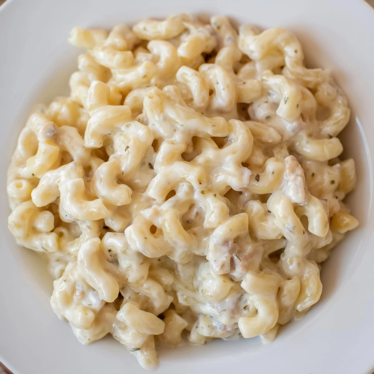 Creamy Boursin mac and cheese with melted cheddar draped over golden elbow pasta