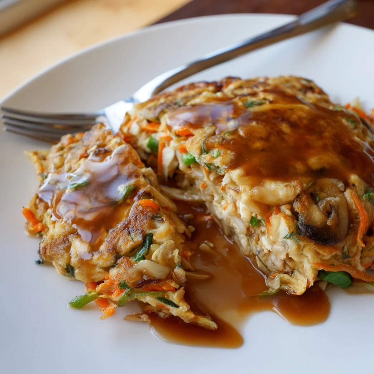 Golden crispy Egg Foo Young patties topped with rich brown gravy and fresh green onions