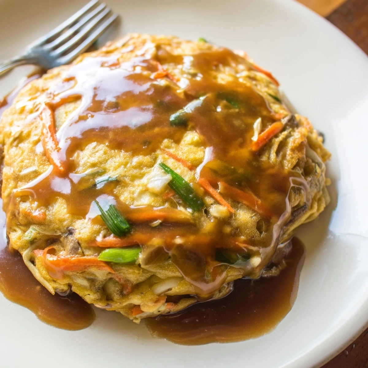 Homemade Egg Foo Young featuring bean sprouts and mushrooms served over steamed white rice