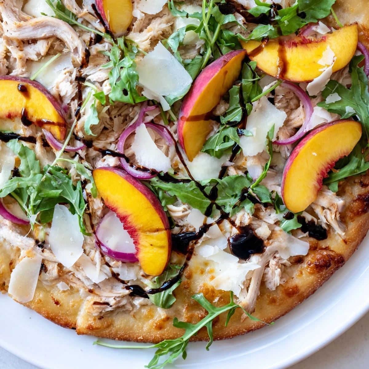 Summer pizza featuring juicy peaches, tender chicken, and creamy ricotta on crisp crust