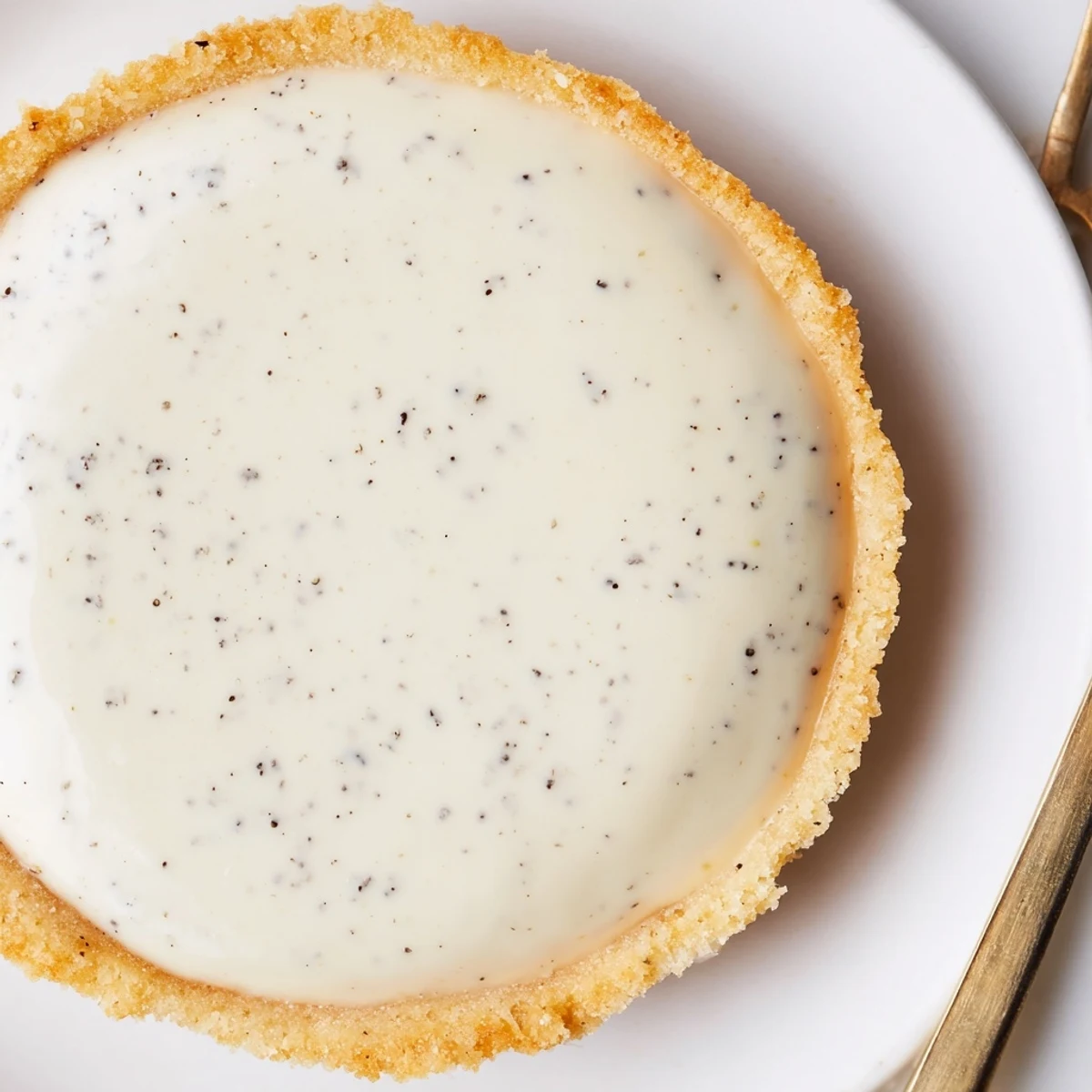 Golden vanilla bean pastry cream tart with crisp buttery crust and glossy finish