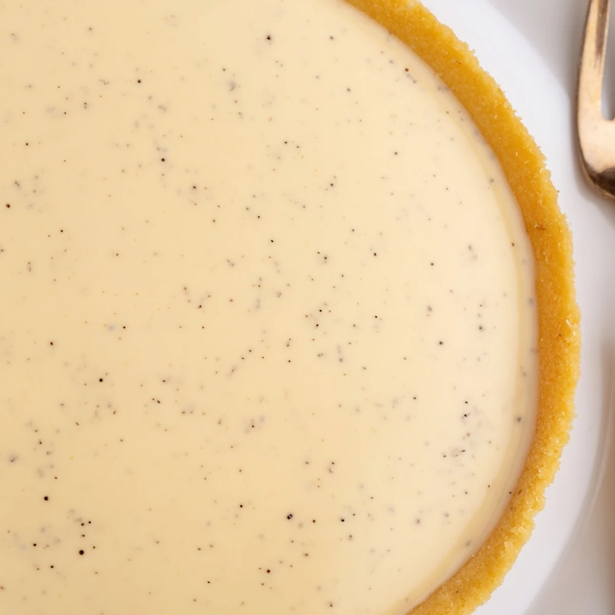 Elegant French tart filled with silky vanilla bean cream on a golden pastry shell