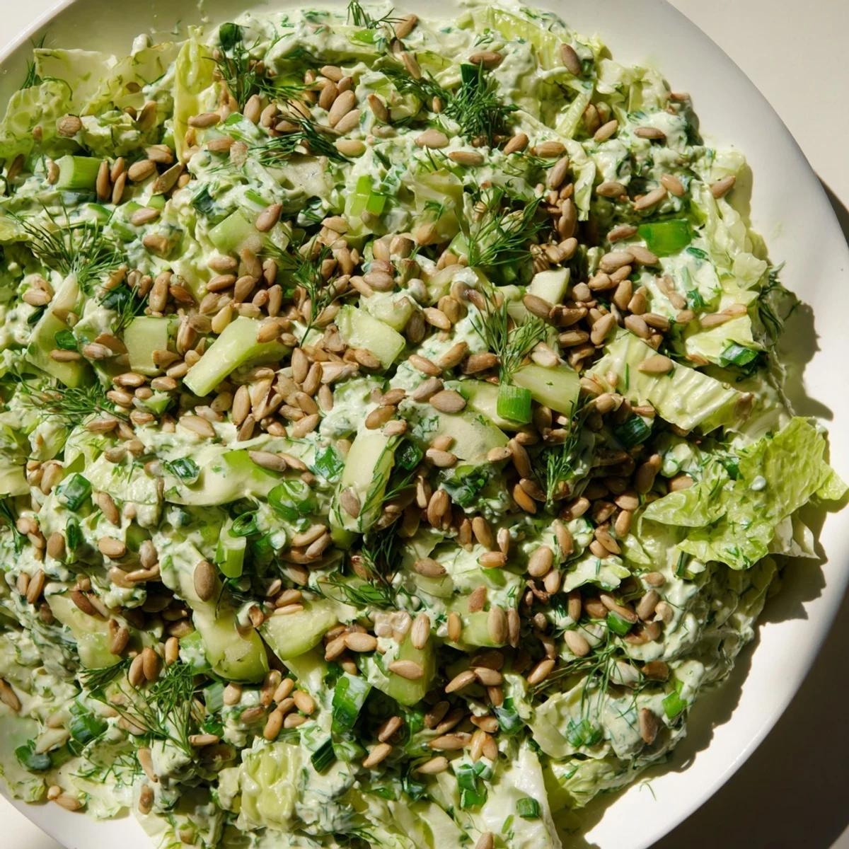 Fresh chopped Green Goddess Salad drizzled with tangy yogurt dressing and sprinkled with sunflower seeds for crunch