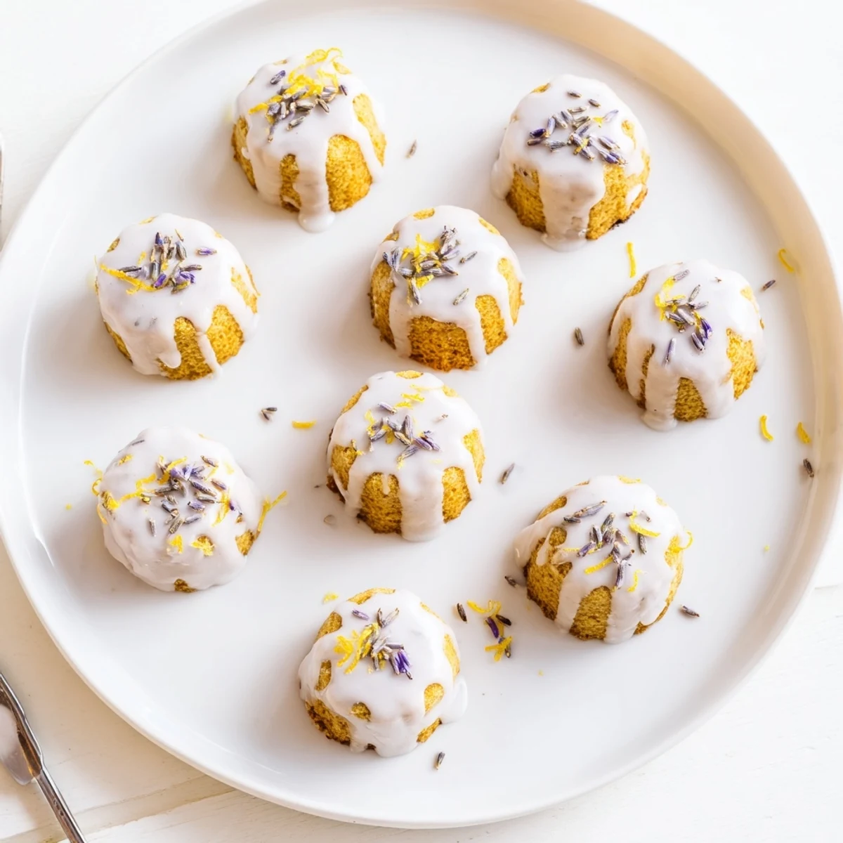 Close-up of moist lemon cupcakes topped with fragrant lavender icing and fresh lemon zest