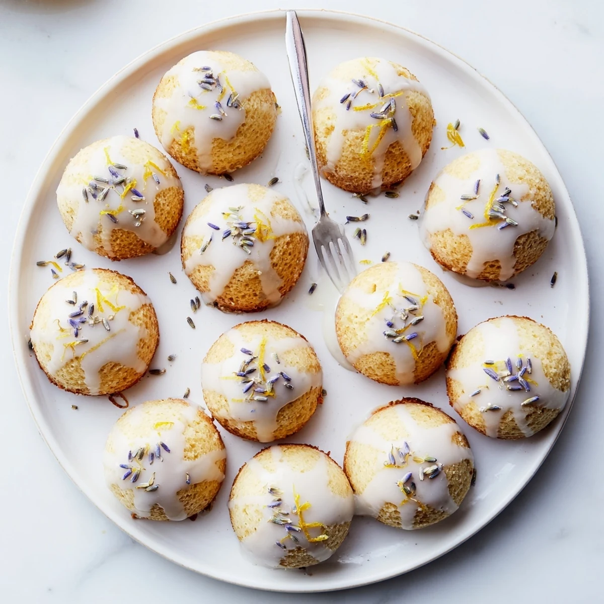 Tea time spread featuring bite-sized lemon cakes glazed with sweet lavender and edible flowers