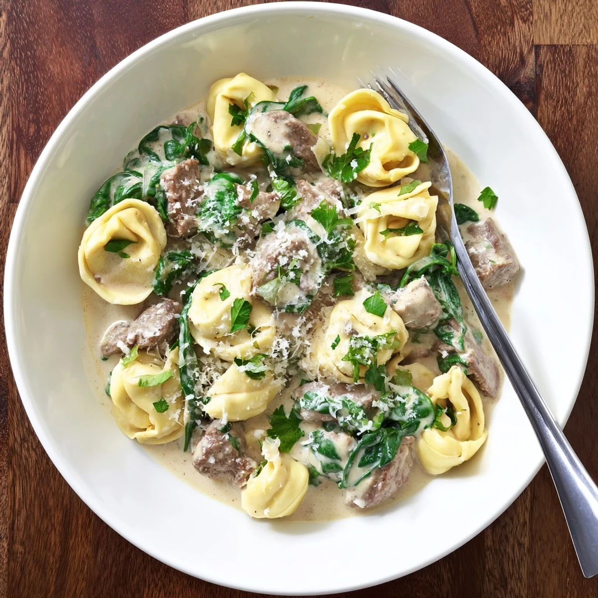 Golden seared steak strips and cheesy tortellini coated in a velvety garlic cream sauce with fresh spinach