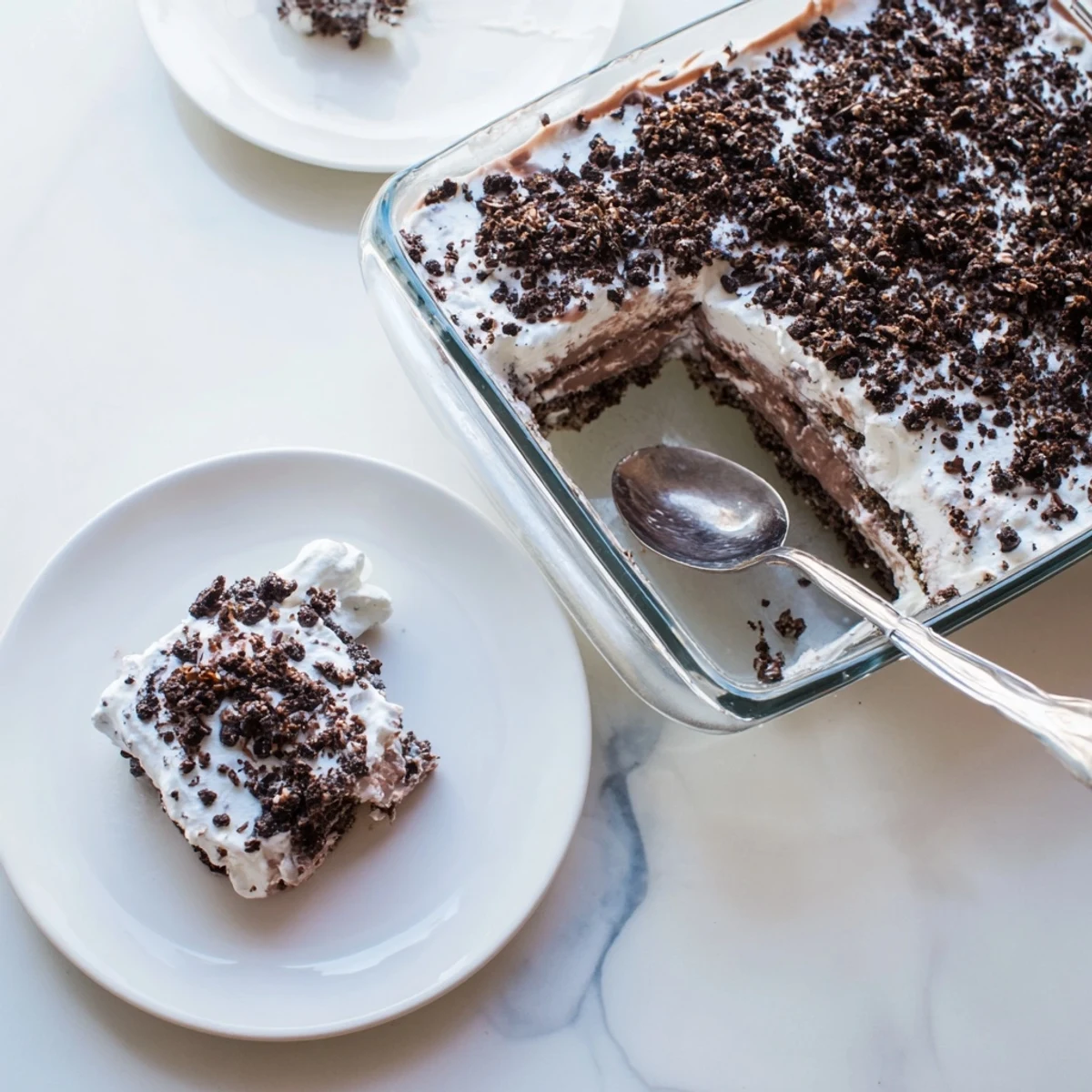 Individual serving jars showing keto dirt cake layered with rich chocolate pudding and fluffy whipped cream under dark chocolate crumble