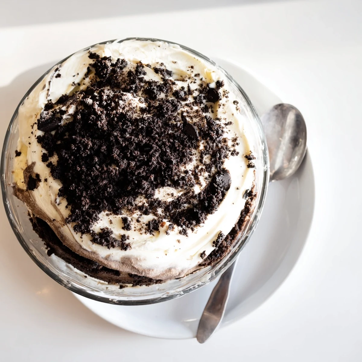 Spoon lifting creamy keto dirt cake with chocolate pudding layers and crunchy chocolate almond dirt topping