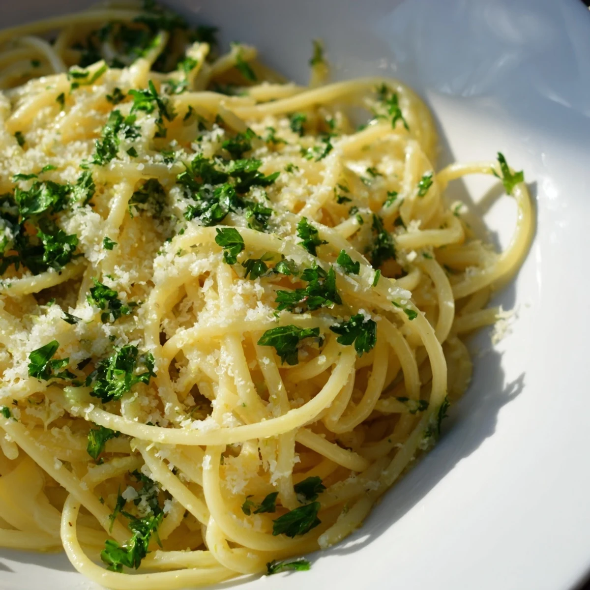 Close up of one pot garlic butter pasta featuring glossy garlic butter sauce and grated Parmesan cheese