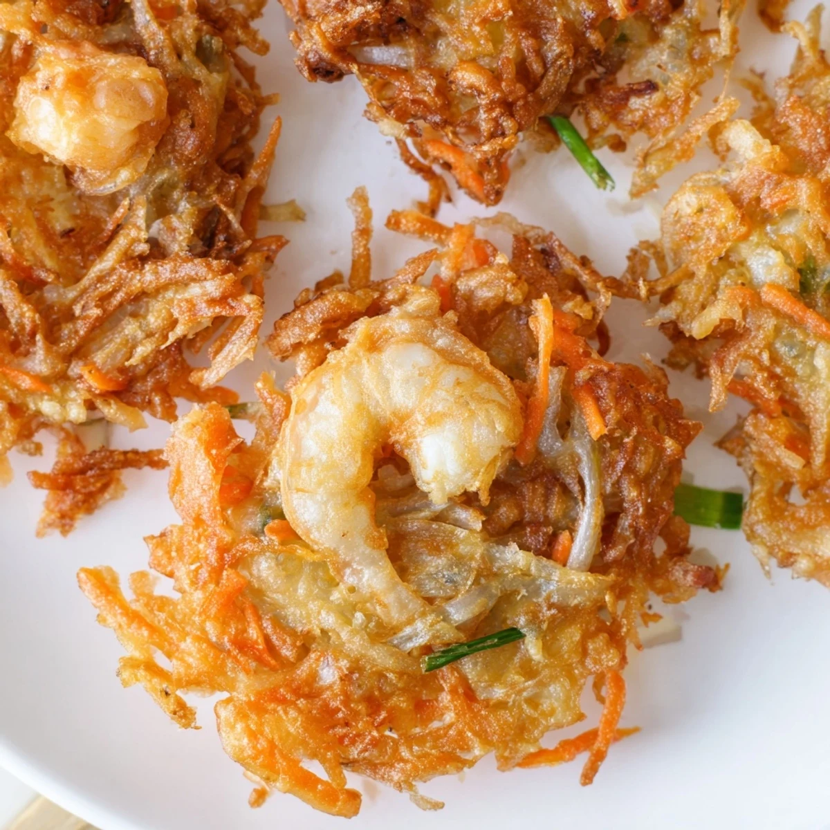 Ukoy Filipino shrimp fritters served hot with vinegar garlic dipping sauce on a white plate