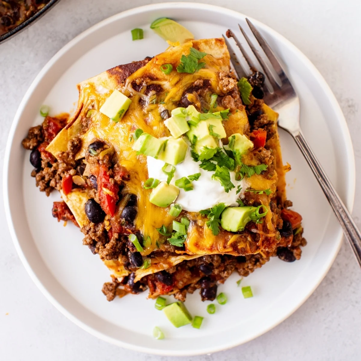 Beef Skillet Enchiladas bubbling in a skillet, melty cheese and rich sauce