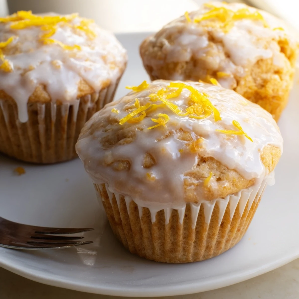 Warm Glazed Lemon Ginger Muffins resting on wire rack, tangy aroma