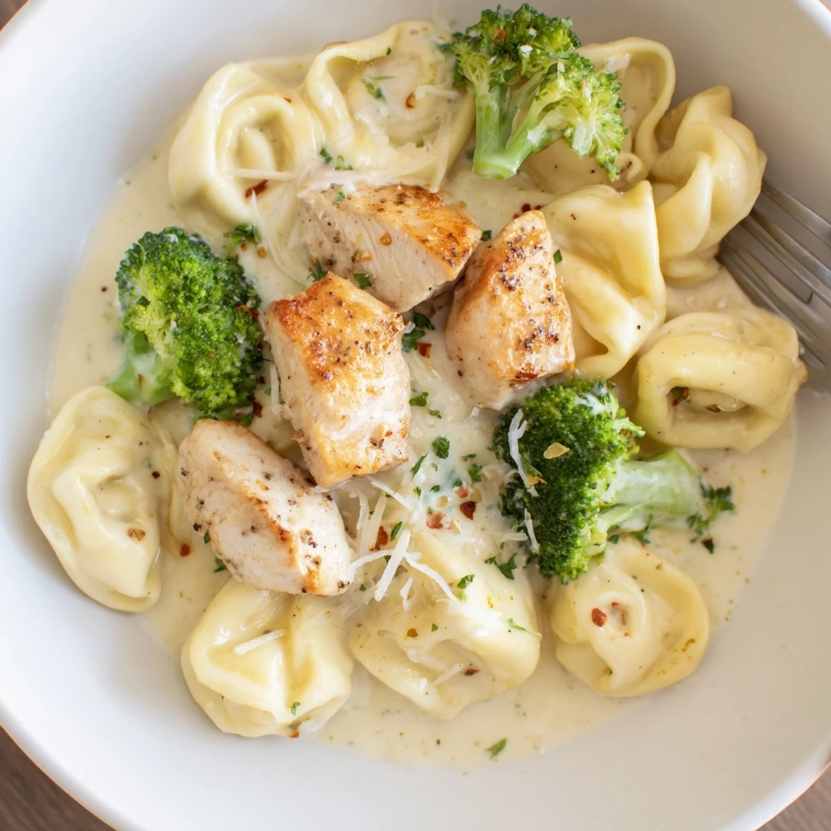 Skillet-ready, bubbling cream coats tortellini in this Creamy Garlic Parmesan Tortellini Chicken Broccoli Recipe  