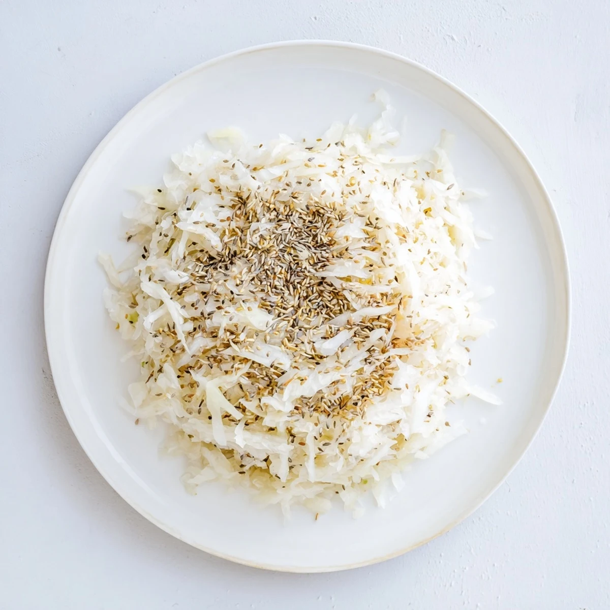 Golden sauerkraut in glass jar with shredded cabbage fermenting in brine