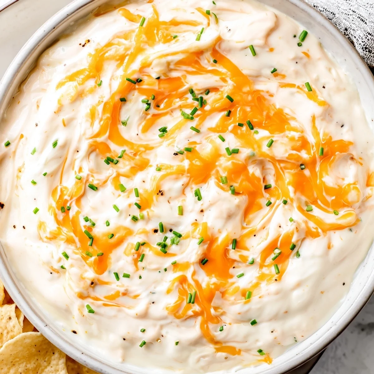 Smooth melted cheese dip topped with paprika and chives ready for dipping
