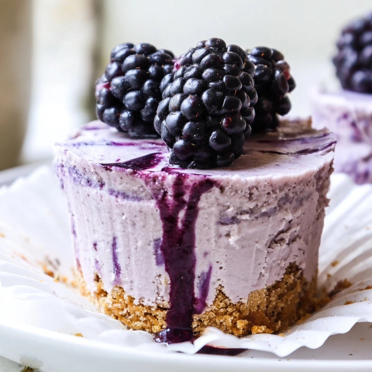 Creamy no bake mini blackberry lavender cheesecakes topped with fresh ripe berries and drizzled sauce
